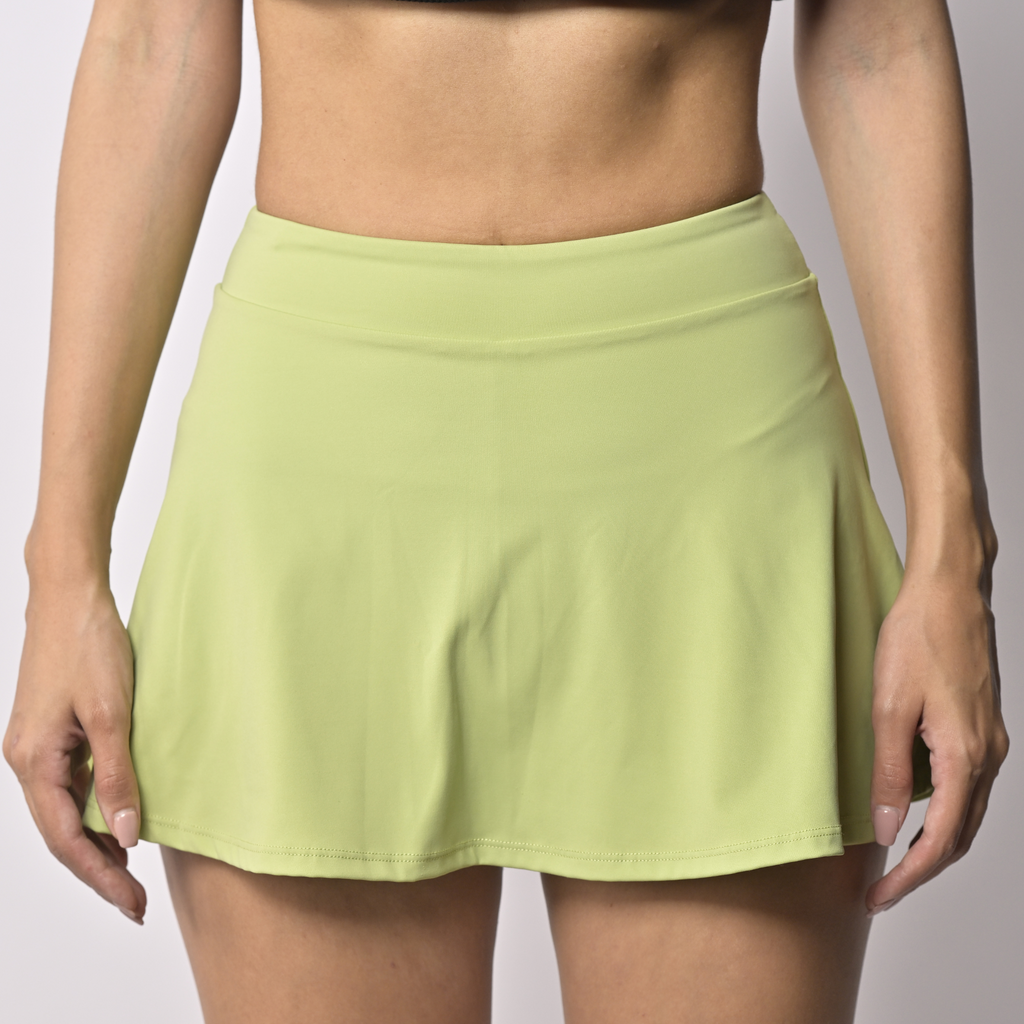 Light green sports skort worn by a woman on a plain background