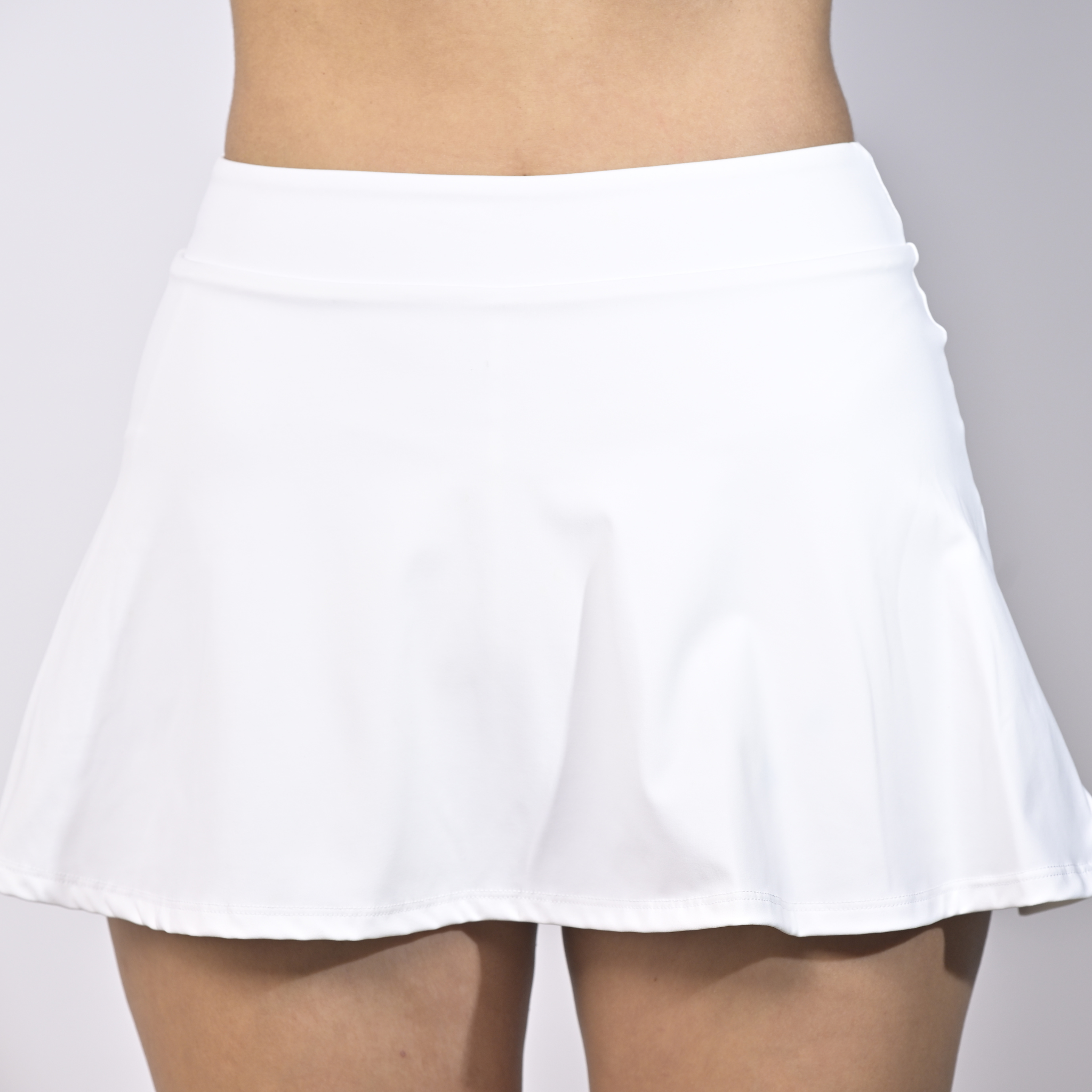 White sports skort worn by a woman on a plain background