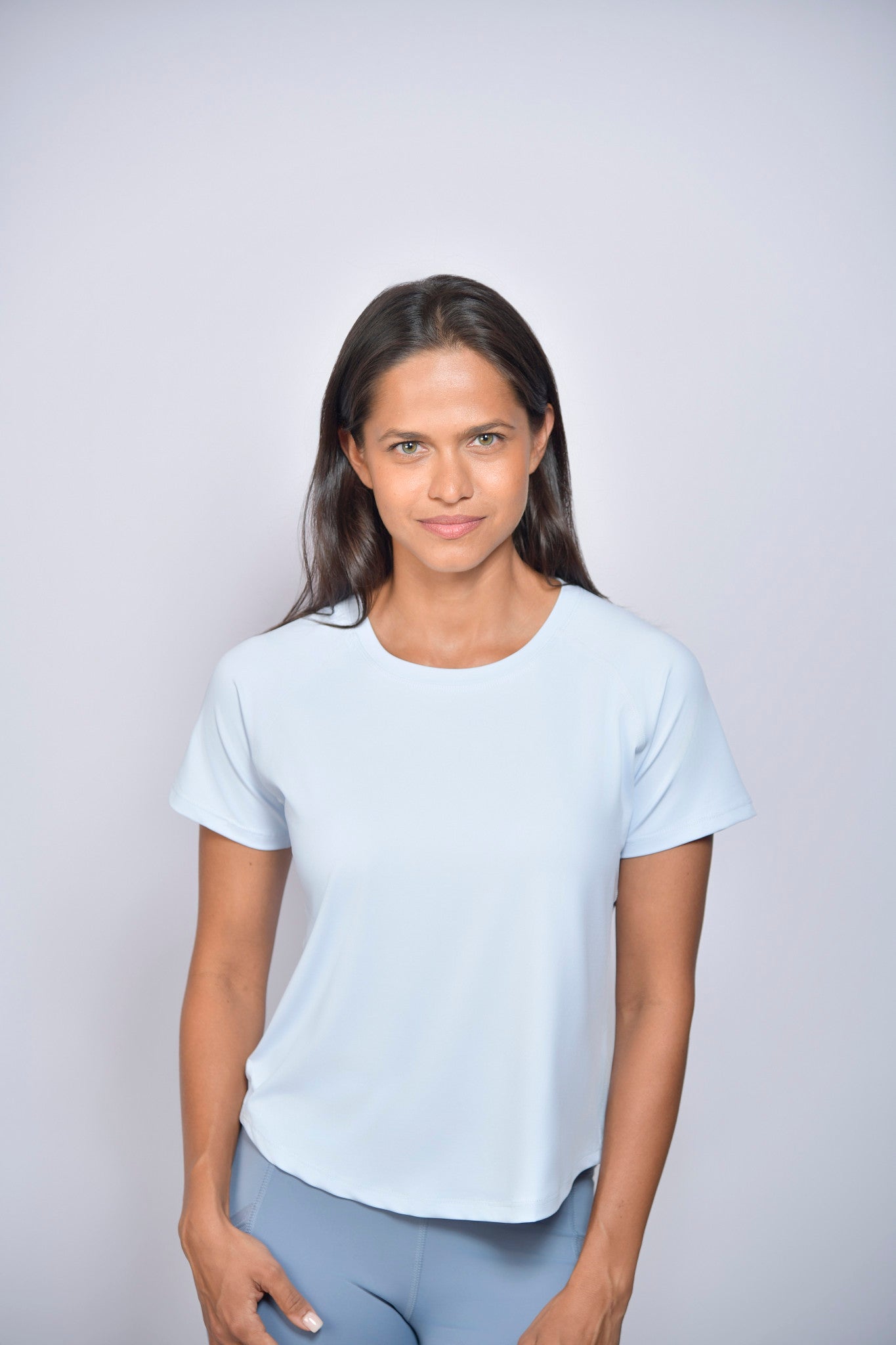 Woman wearing a light-blue sports t-shirt against a plain background
